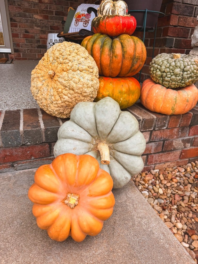 Close view of stacked orange, blue, and turban gourds